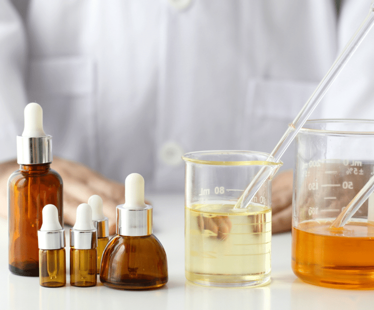 A lab-coated individual is presenting a bottle of liquid