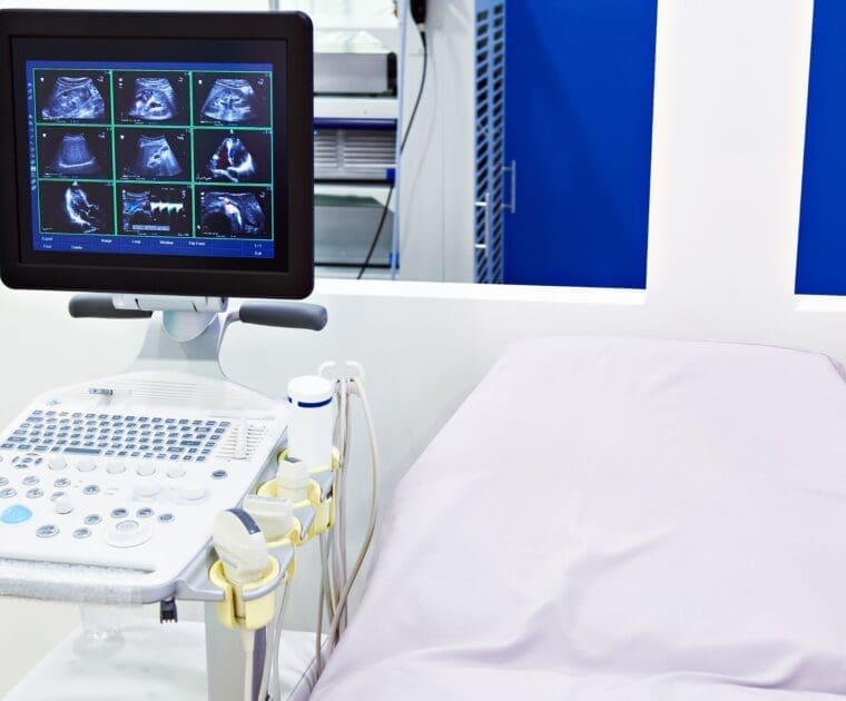 A hospital bed with a monitor beside it