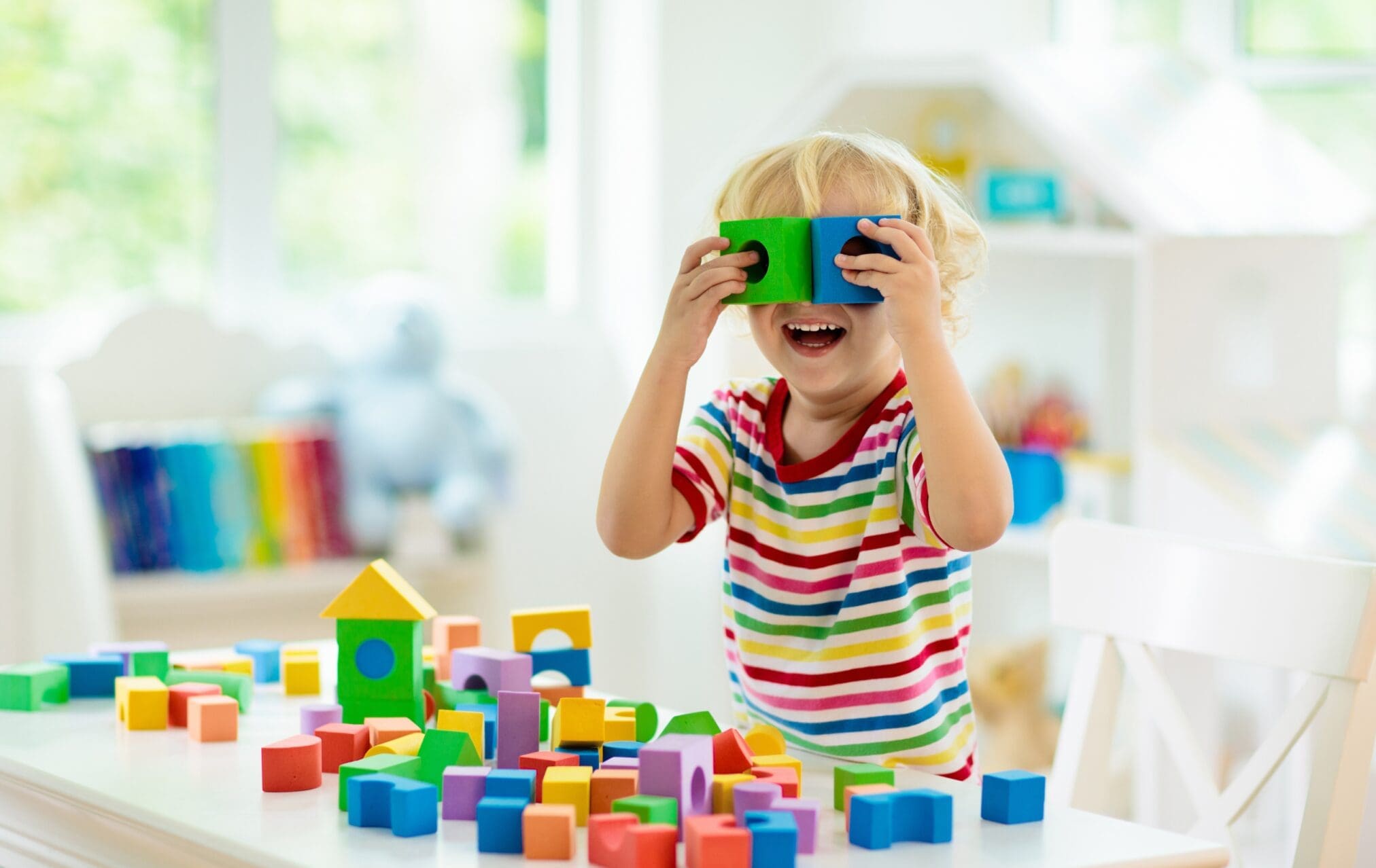 Kid playing with wooden colorfull blocks