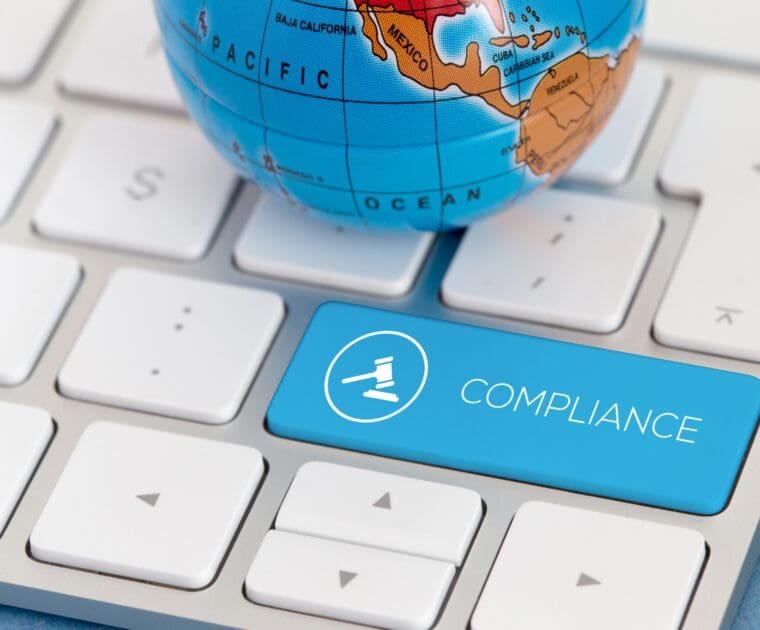 Global compliance concept with compliance key on keyboard and world globe.