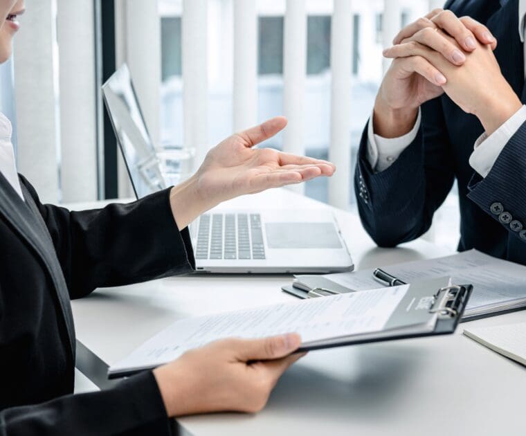Regulatory consultant discussing compliance requirements with clients during a business meeting.